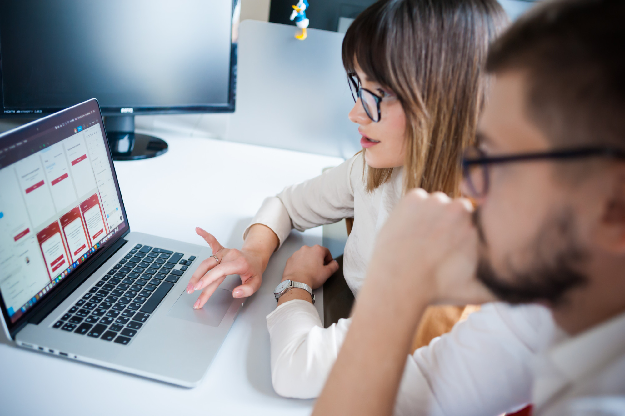 Due professionisti analizzano flussi di test scenario su un software in fase di sviluppo, seduti davanti a un laptop in ufficio.
