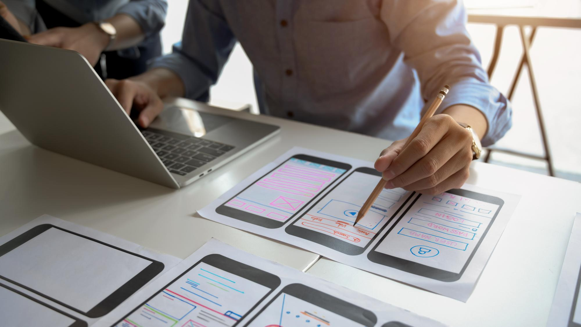 ux designer studia il layout della schermata di un'applicazione mobile in fase di sviluppo