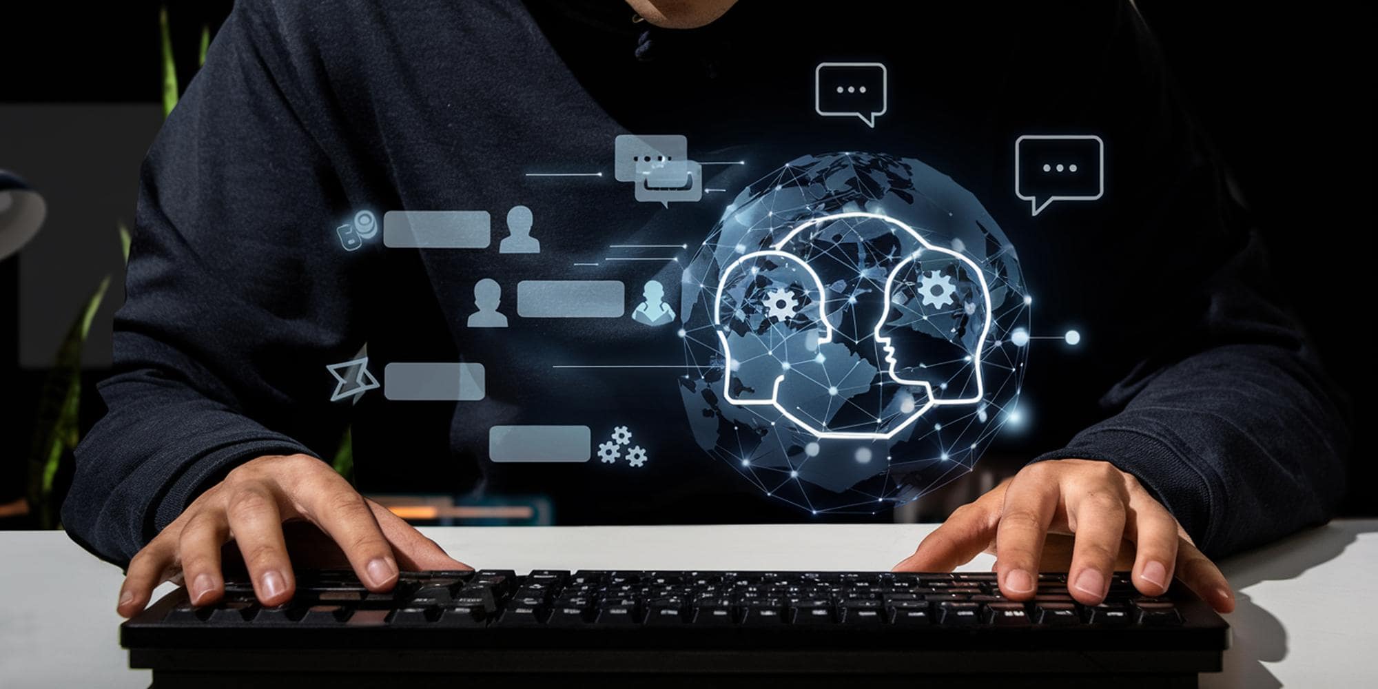 schermo del pc e primo piano su mani poggiate sulla tastiera del pc con icone relative al mondo del Natural Language Processing NLP